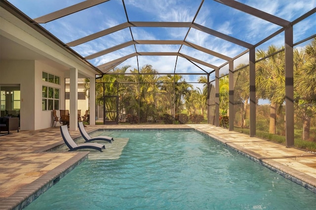 view of swimming pool with glass enclosure and a patio area