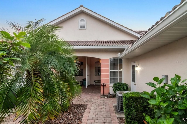 doorway to property with cooling unit and a patio