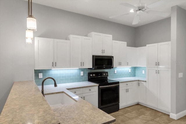 kitchen featuring sink, black appliances, pendant lighting, light tile patterned floors, and white cabinets