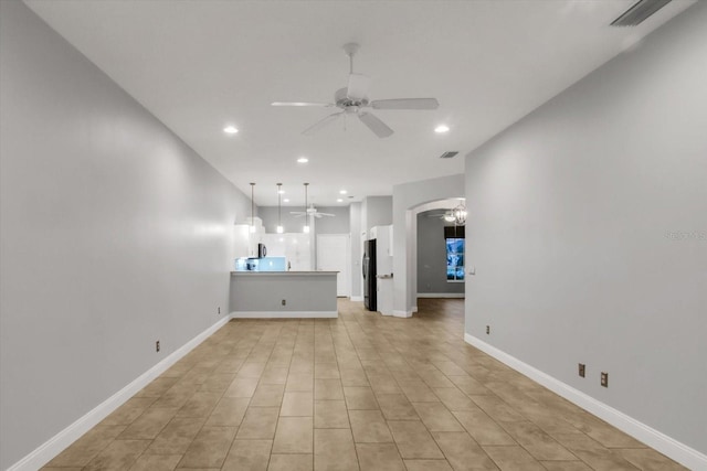 unfurnished living room featuring light tile patterned floors and ceiling fan