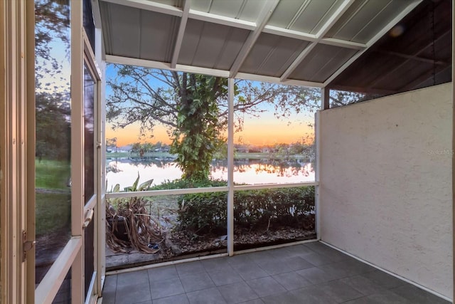 unfurnished sunroom featuring a water view