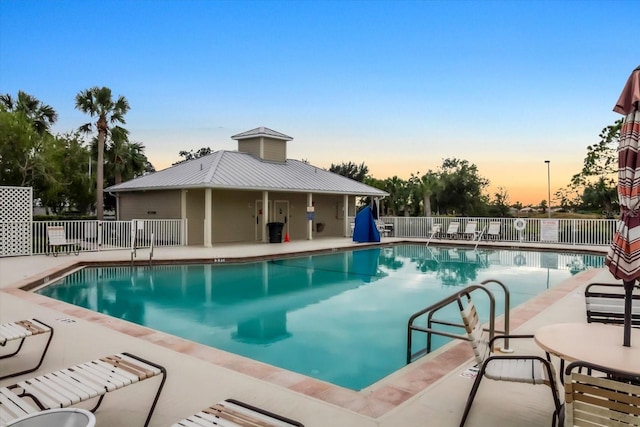 pool at dusk with a patio