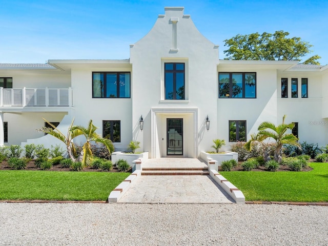 view of front of home featuring a balcony and a front lawn