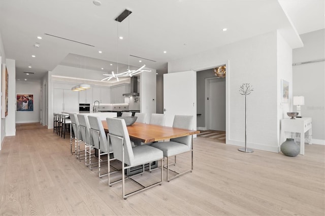 dining space with sink and light hardwood / wood-style flooring