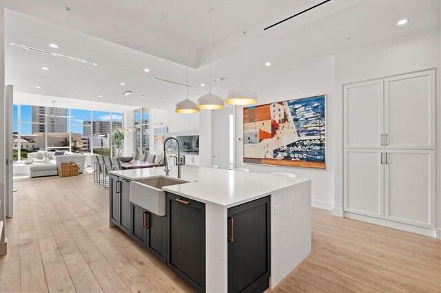 1335 2nd St Unit 301, Sarasota, FL 34236 - kitchen featuring open floor plan, light wood finished floors, light countertops, a kitchen island with sink, and recessed lighting