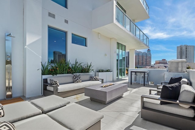 view of patio with an outdoor living space with a fire pit