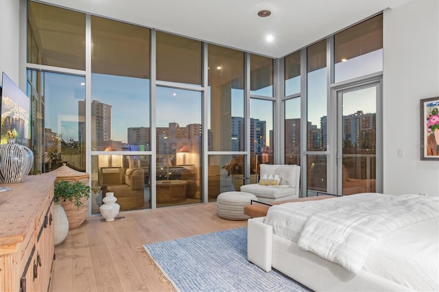 bedroom with light hardwood / wood-style floors and floor to ceiling windows