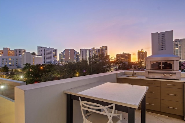 balcony at dusk with sink and a fireplace