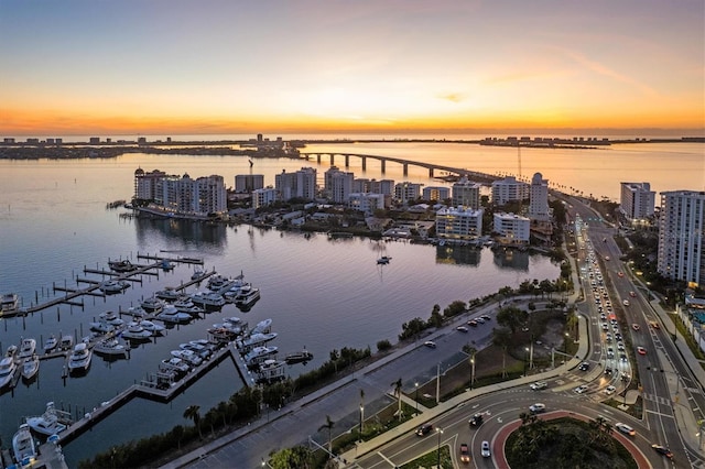 aerial view at dusk featuring a water view