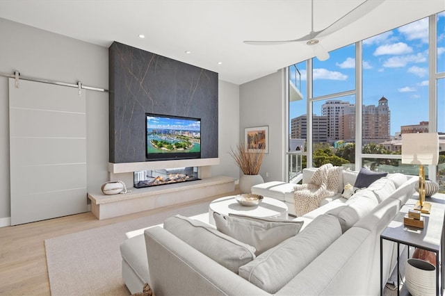 1335 2nd St Unit 301, Sarasota, FL 34236 - living area featuring wood finished floors, a wall of windows, a barn door, recessed lighting, and ceiling fan