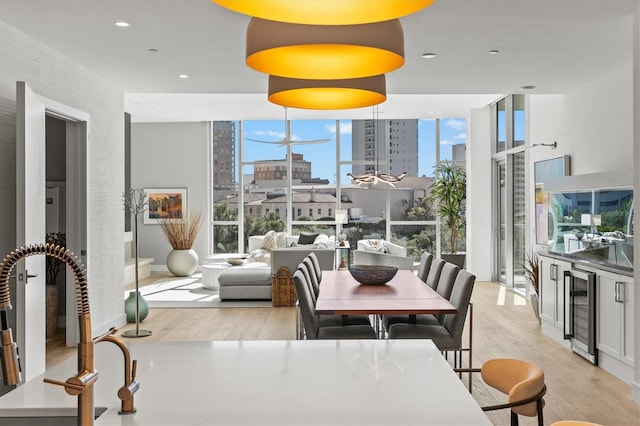 1335 2nd St Unit 301, Sarasota, FL 34236 - dining space with beverage cooler, light wood-type flooring, a wall of windows, a city view, and recessed lighting
