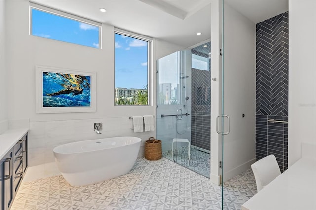 1335 2nd St Unit 301, Sarasota, FL 34236 - bathroom with tile walls, vanity, a stall shower, a freestanding bath, and recessed lighting