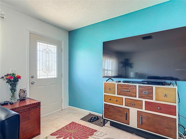 tiled foyer entrance featuring a textured ceiling