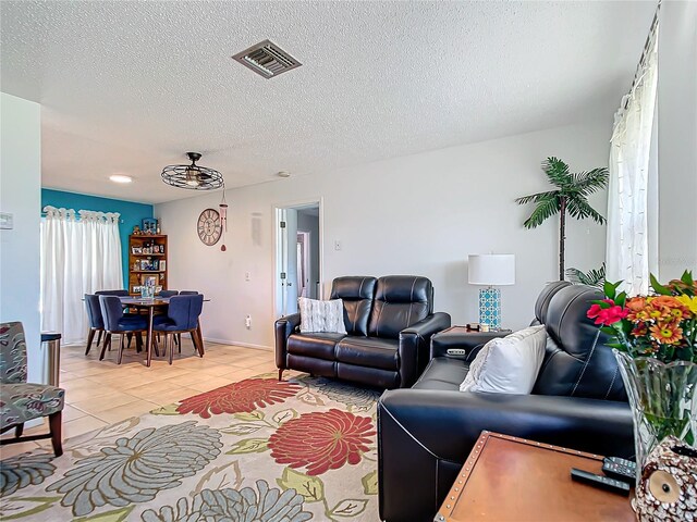 tiled living room featuring a textured ceiling