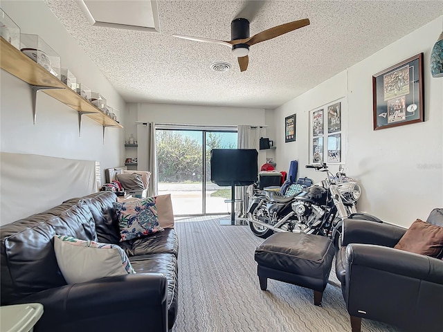 living room with carpet flooring, a textured ceiling, and ceiling fan