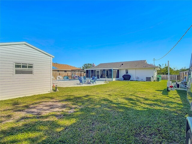 view of yard with a sunroom, cooling unit, and a patio area