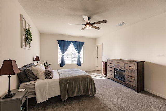 bedroom featuring ceiling fan, carpet floors, and a textured ceiling