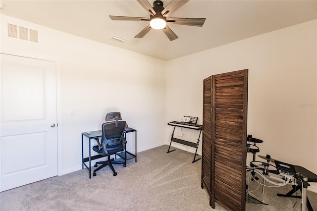 carpeted home office featuring ceiling fan