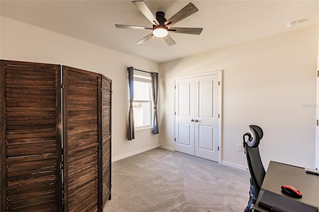 unfurnished office with ceiling fan and light colored carpet