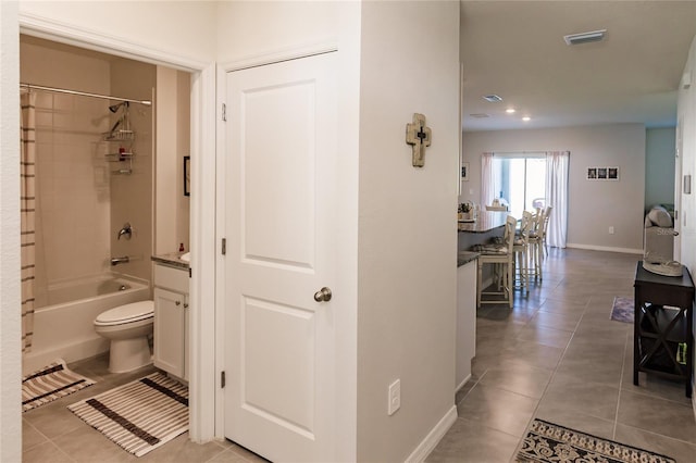 bathroom with tile patterned flooring, shower / tub combo with curtain, and toilet