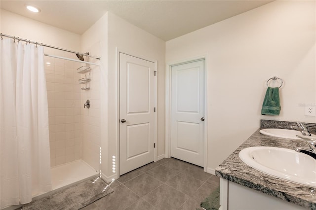 bathroom featuring tile patterned flooring, vanity, and walk in shower