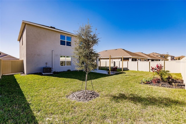 rear view of property with a yard and central AC