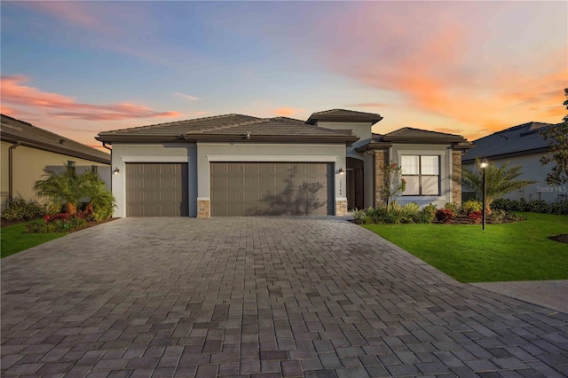 prairie-style house featuring a lawn and a garage