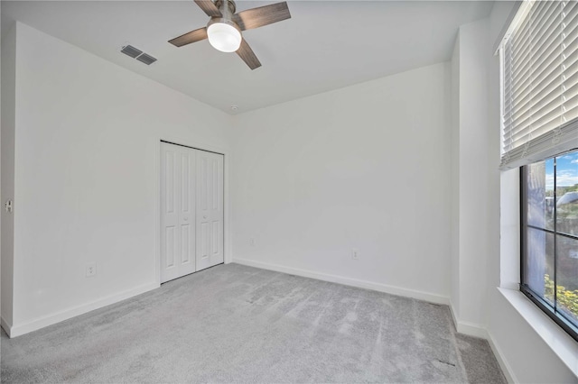 carpeted spare room with ceiling fan