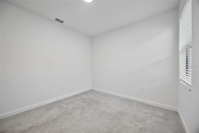 spare room featuring light colored carpet