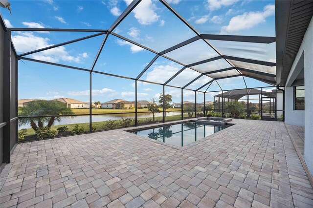 view of pool with a patio area, a lanai, an in ground hot tub, and a water view