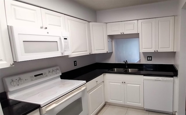 kitchen featuring sink, white cabinets, light tile patterned flooring, and white appliances