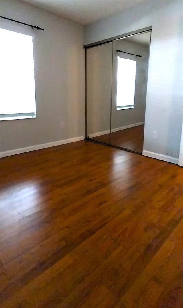 unfurnished bedroom with hardwood / wood-style flooring and a closet