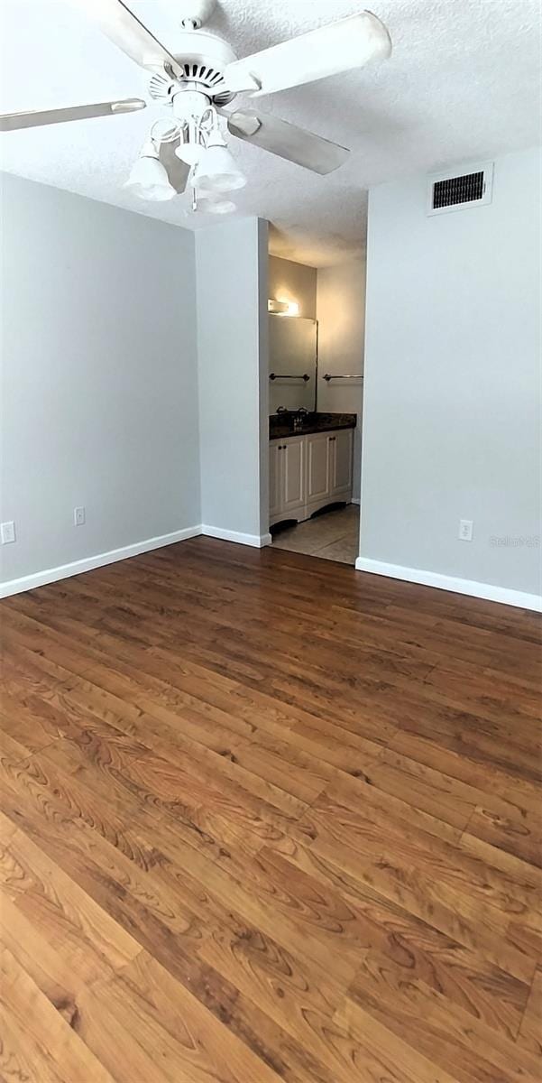 unfurnished living room featuring ceiling fan, wood-type flooring, and a textured ceiling