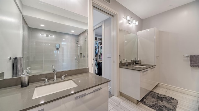 bathroom with tiled shower, vanity, and tile patterned floors