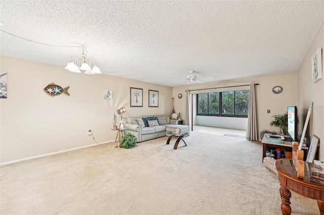 living room featuring ceiling fan with notable chandelier, carpet, and a textured ceiling