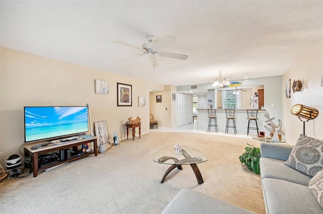 carpeted living room with ceiling fan with notable chandelier and a textured ceiling