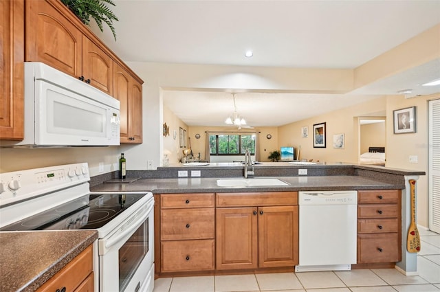 kitchen with sink, light tile patterned floors, white appliances, and an inviting chandelier