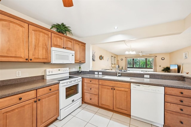 kitchen featuring kitchen peninsula, white appliances, ceiling fan with notable chandelier, sink, and light tile patterned flooring