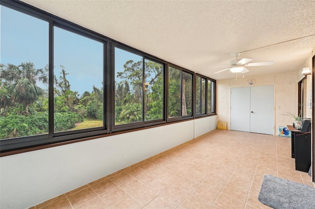 unfurnished sunroom featuring ceiling fan