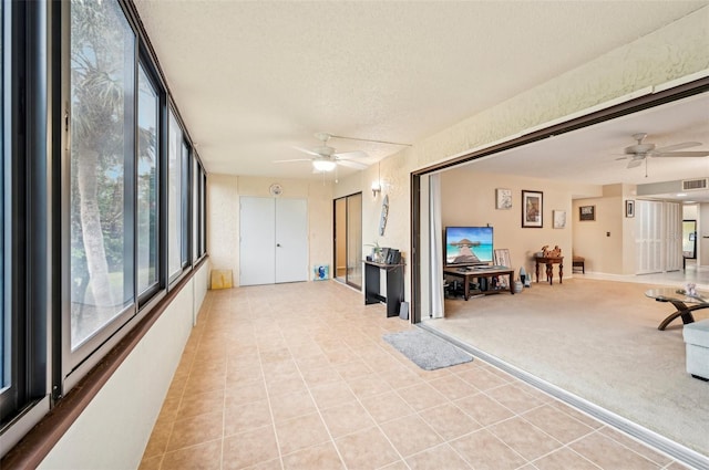 interior space featuring ceiling fan, plenty of natural light, and a textured ceiling