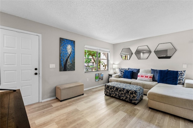 living room with a textured ceiling and light hardwood / wood-style floors