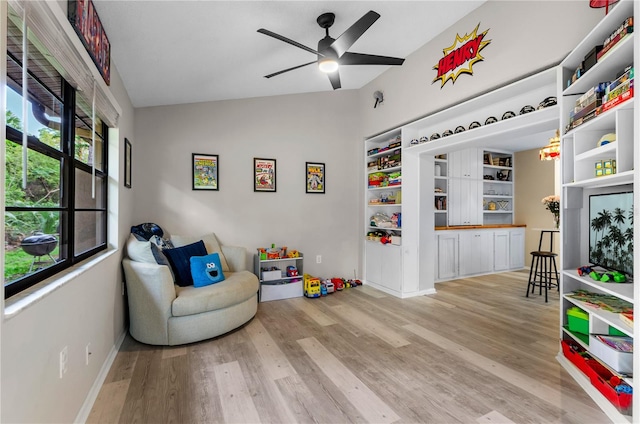 sitting room featuring baseboards, lofted ceiling, light wood-style flooring, and a ceiling fan