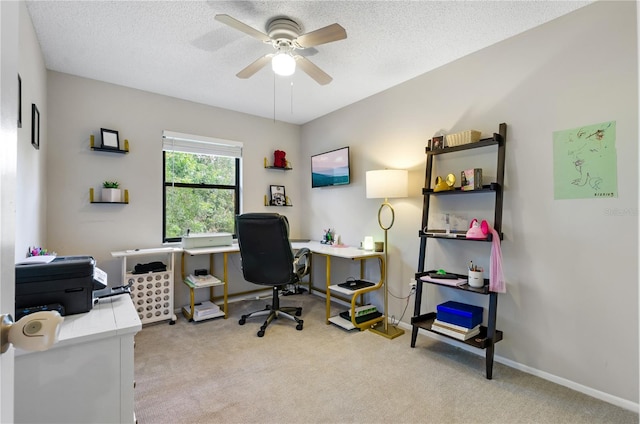 carpeted home office featuring a textured ceiling and ceiling fan