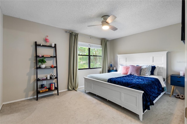 bedroom with a ceiling fan, light colored carpet, a textured ceiling, and baseboards