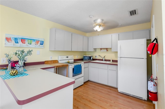 3415 51st Avenue Cir W Unit 206, Bradenton, FL 34210 - kitchen featuring white appliances, a peninsula, light wood-type flooring, ceiling fan, and light countertops