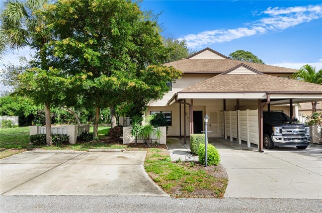 view of front of home with a carport and roof with shingles