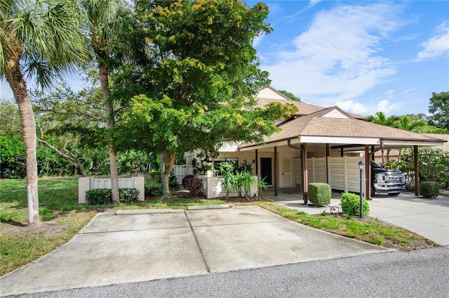 view of front of home with a carport and a shingled roof