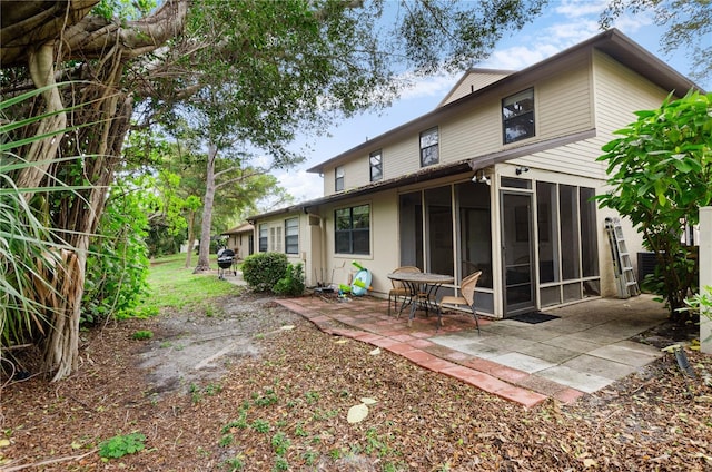 back of property with a patio area and a sunroom