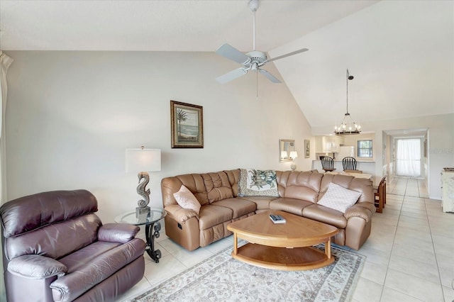 tiled living room featuring ceiling fan with notable chandelier and high vaulted ceiling