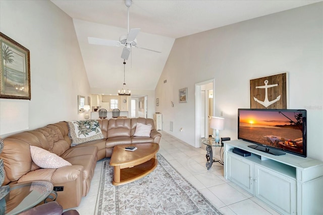 tiled living room with ceiling fan with notable chandelier and high vaulted ceiling